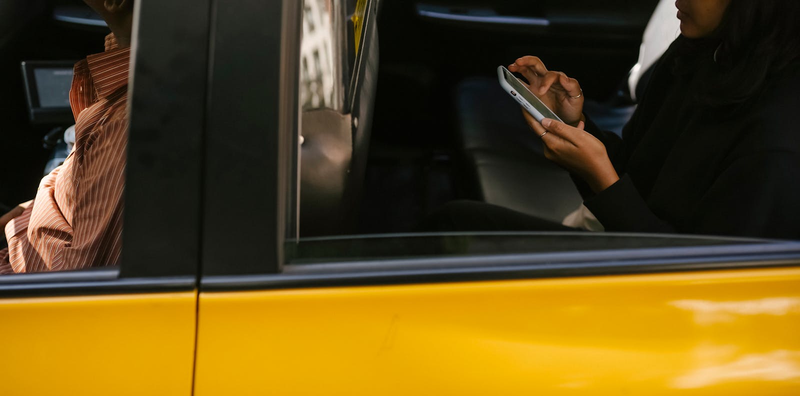 Passag&egrave;re utilisant son t&eacute;l&eacute;phone dans un taxi